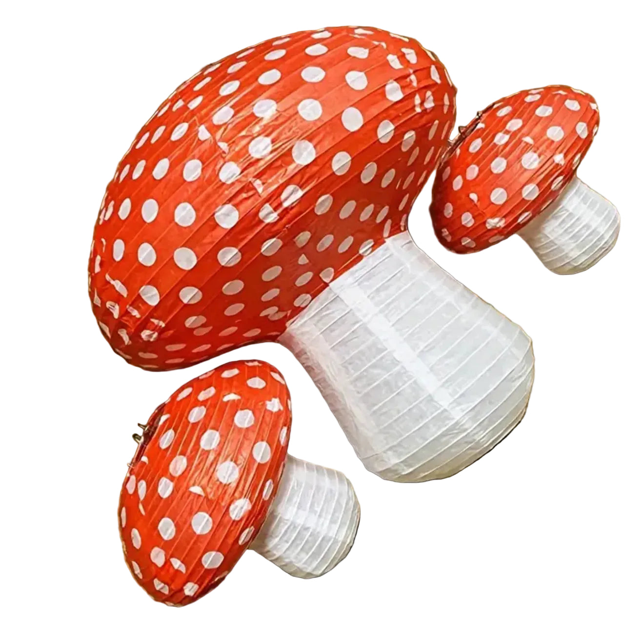 Pop up paper lantern mushroom decorations with red caps and white polka dots on a wooden floor.